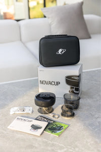 Portable cupping massager set with accessories, user manuals, and carrying case displayed on a table in a modern living room.
